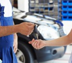 cropped view of mechanic giving car keys to female client