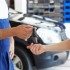 cropped view of mechanic giving car keys to female client