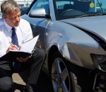 Loss Adjuster Inspecting Car Involved In Accident